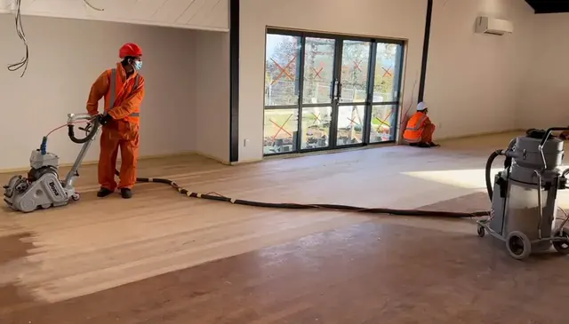 FlooringPro technician sanding a wooden floor in Auckland