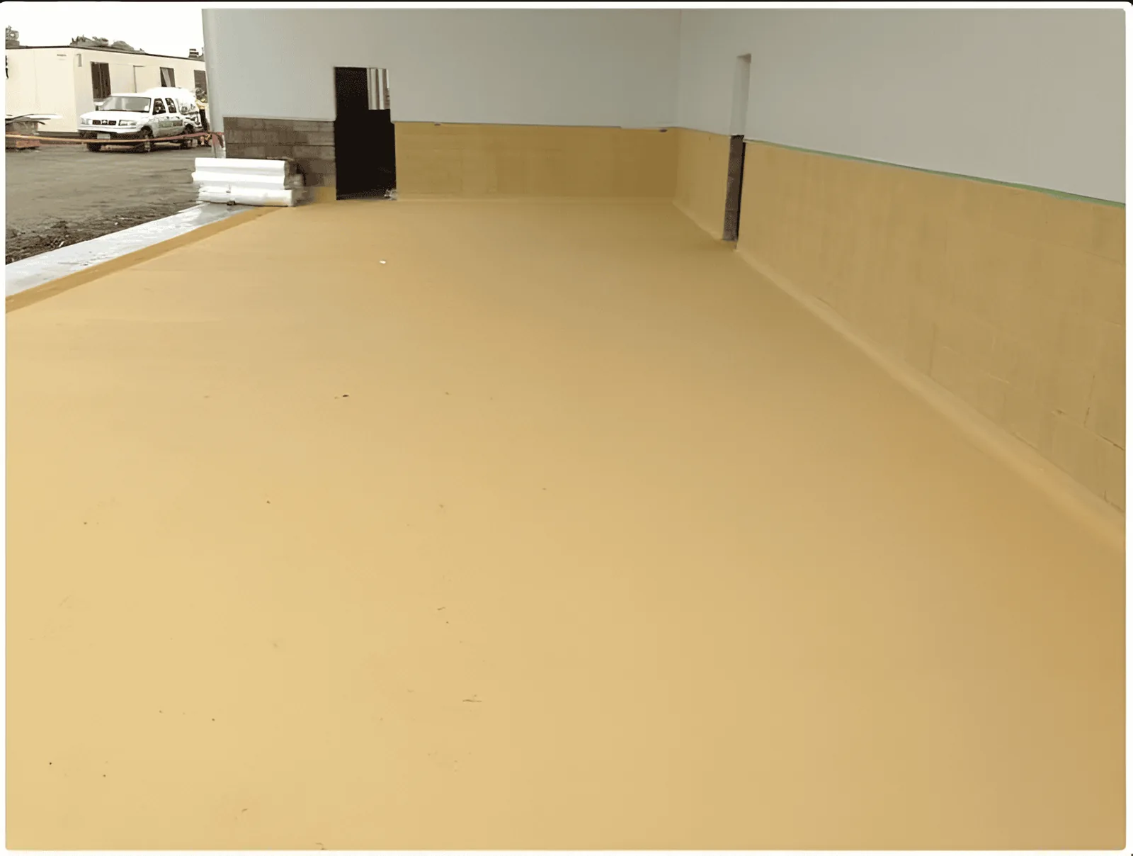 Completed tan concrete floor coating in a clean utility space
